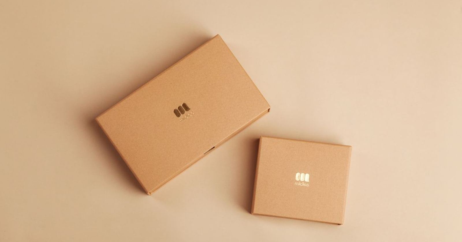 Two plainly wrapped kraft paper gifts on a warm neutral background