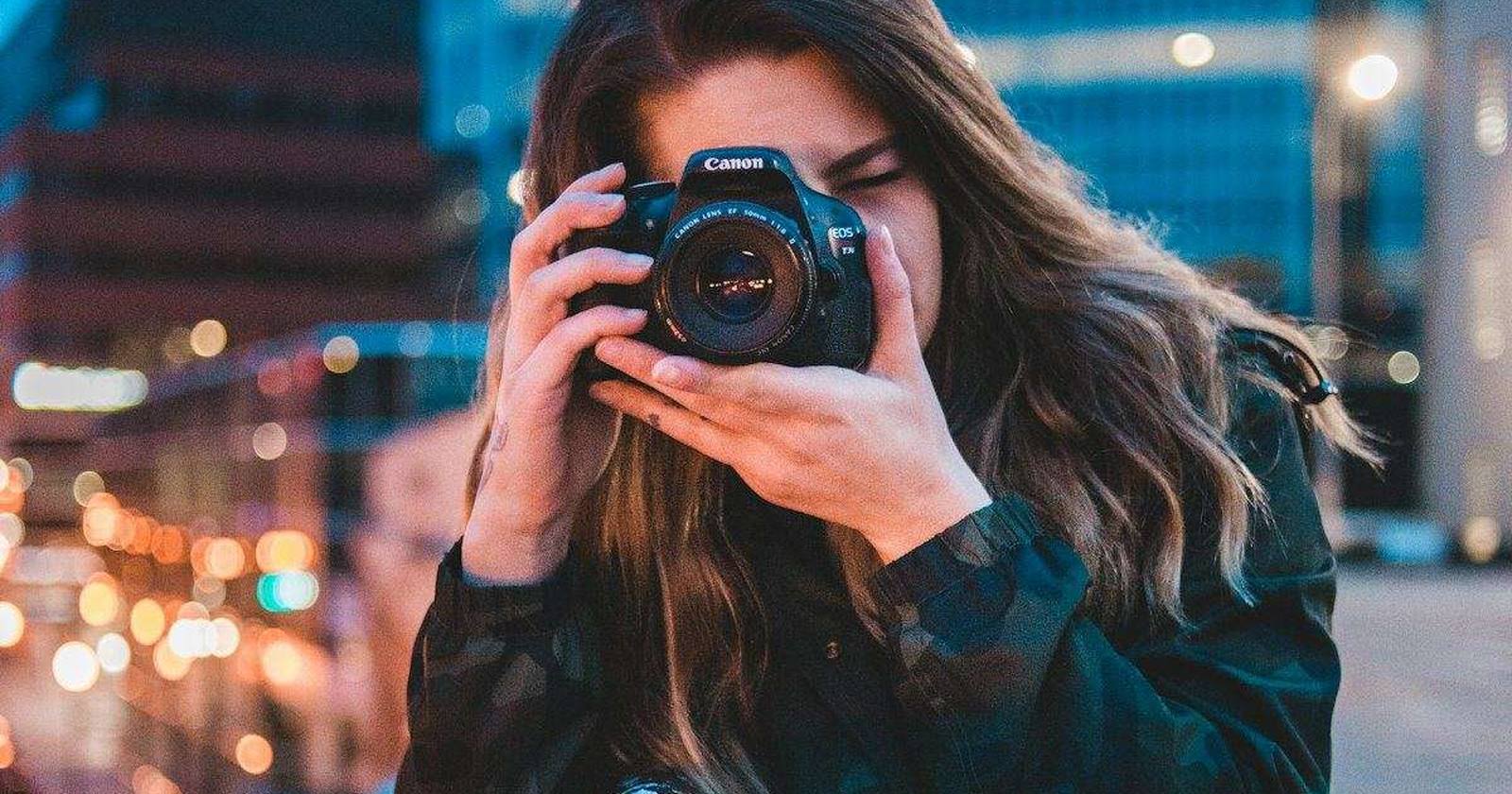 A guest raising a camera to photograph a lit scene at night