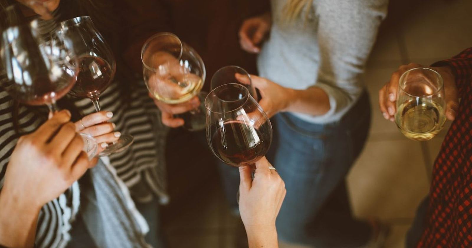Friends raising and clinking glasses together in a warm toast