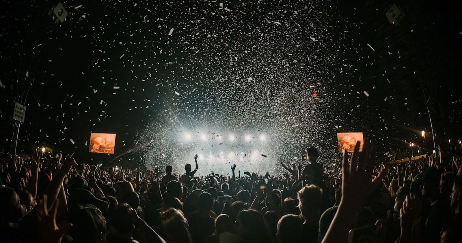 A packed crowd with hands raised at a live music event