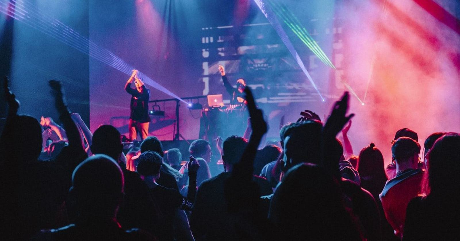 A crowd dancing under stage lights at a party