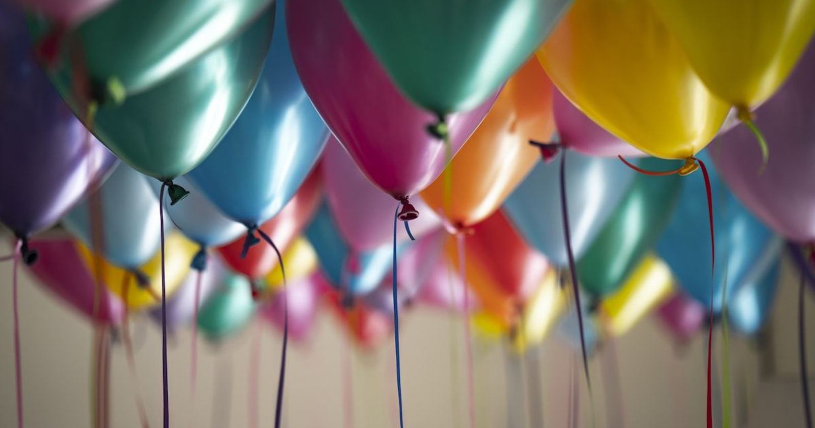 Brightly colored balloons gathered against a ceiling